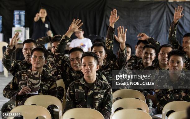 This photo taken on May 11, 2018 shows soldiers raising their hands during a lecture about fake news in Philippine Army Camp Jaime Bitong in Baler,...