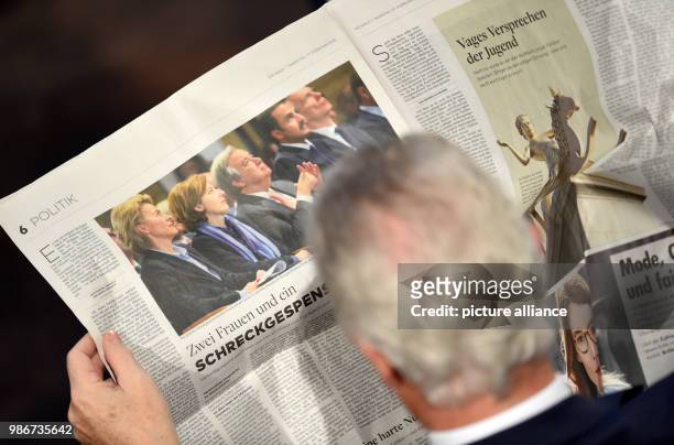 Participant reads the papers with the heading 'Zwei Frauen und ein Schreckgespenst' at the 54th Munich Security Conference at the hotel 'Bayerischer...