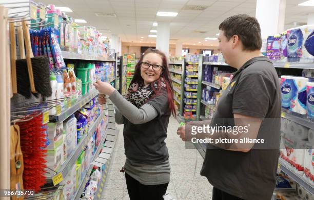 Febuary 2018, Germany, Rostock: Nadine Berninger, branch manager of the Cap Markt in the Seidelstrasse, applies pricetags to goods with Benjamin...