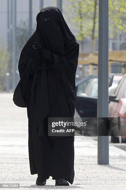 Woman wearing a niqab, the islamic full veil, walks in a street of Venissieux near Lyon, eastern France, on April 22, 2010. French government will...