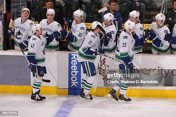 Kyle Wellwood, Ryan Kesler and Alexander Edler of the Vancouver Canucks celebrate with the bench after a goal against the Los Angeles Kings in Game...