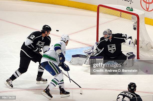 Jonathan Quick and Randy Jones of the Los Angeles Kings watch as Tanner Glass of the Vancouver Canucks shoots the puck wide in Game Four of the...