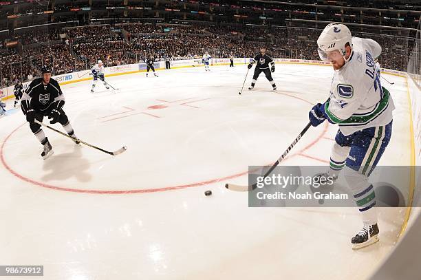 Daniel Sedin of the Vancouver Canucks skates with the puck against Rob Scuderi of the Los Angeles Kings in Game Four of the Western Conference...