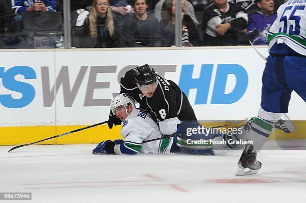 Alexandre Burrows of the Vancouver Canucks is knocked to the ice by Drew Doughty of the Los Angeles Kings in Game Four of the Western Conference...