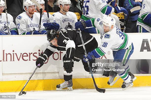 Jack Johnson of the Los Angeles Kings skates with the puck against Pavol Demitra of the Vancouver Canucks in Game Four of the Western Conference...