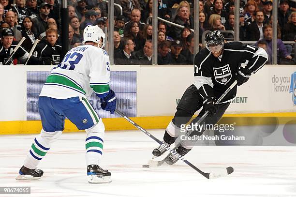 Wayne Simmonds of the Los Angeles Kings skates with the puck against Henrik Sedin of the Vancouver Canucks in Game Four of the Western Conference...