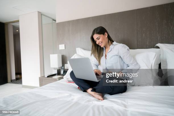 mulher de negócios em casa trabalhando em um laptop na cama - hóspede - fotografias e filmes do acervo