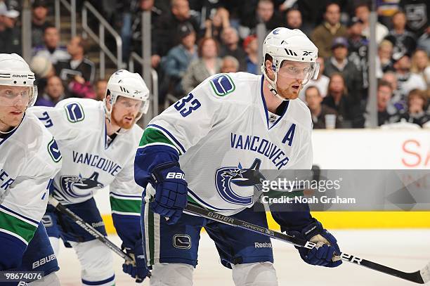 Daniel Sedin and Henrik Sedin of the Vancouver Canucks stand on the ice during a break in the action against the Los Angeles Kings in Game Four of...