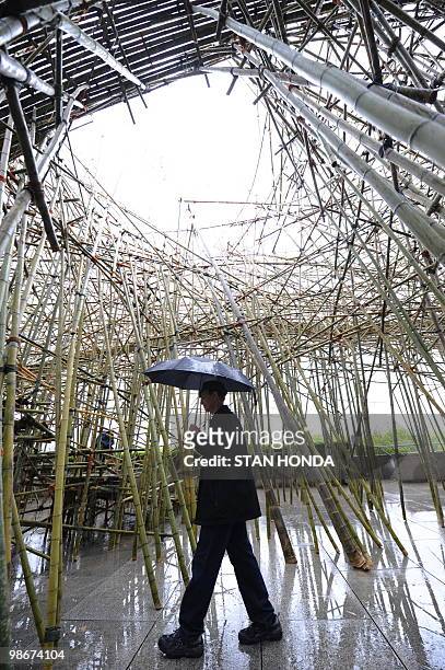Visitor walks under the sculpture "Big Bambú: You Can't, You Don't, and You Won't Stop" by US artists Doug and Mike Starn, April 26 a large bamboo...