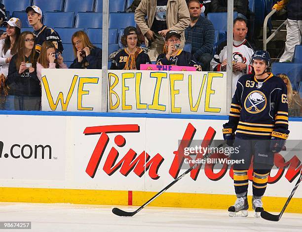 Fans hold a "We Believe" sign on the glass as Tyler Ennis of the Buffalo Sabres skates in warmups before playing against the Boston Bruins in Game...