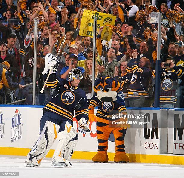 Ryan Miller of the Buffalo Sabres acknowledges the fans' cheers as mascot Sabertooth looks on after their 4-1 win against the Boston Bruins in Game...
