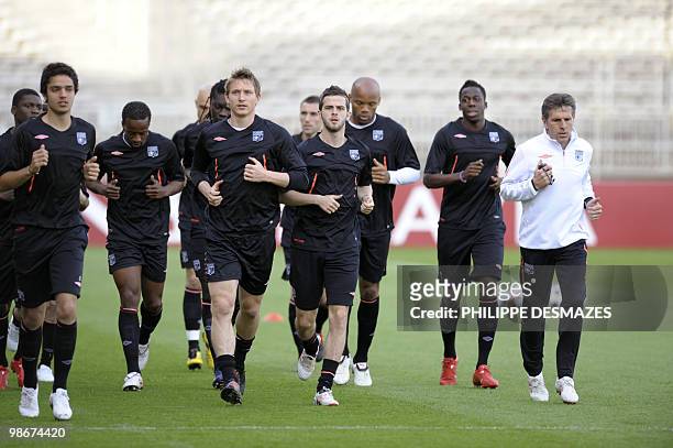 Lyon's coach Claude Puel runs with his players during a training session on April 26, 2010 at the Gerland stadium in Lyon, on the eve of their...