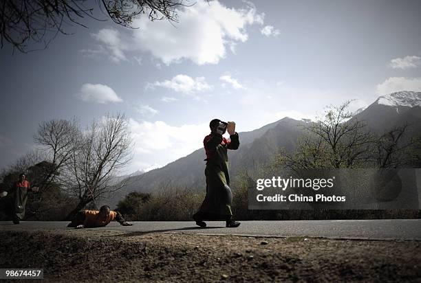 Tibetan pilgrims pray during their pilgrimage trip along a road at the Bayi Township on April 26, 2010 in Nyingchi County of Tibet Autonomous Region,...