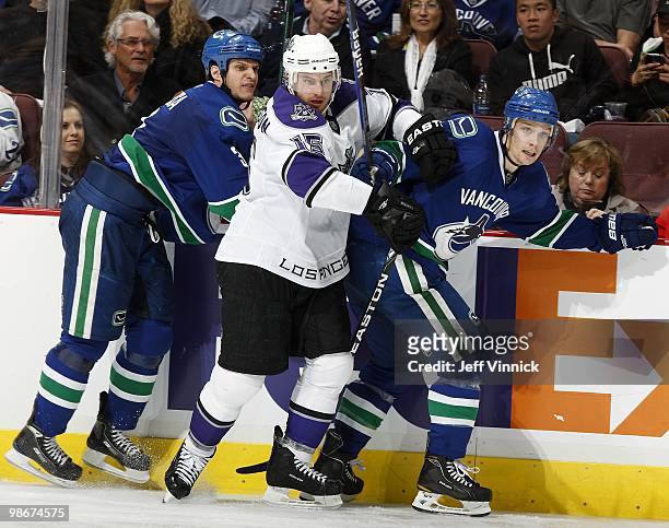 Mason Raymond and Kevin Bieksa of the Vancouver Canucks and Brad Richardson of the Los Angeles Kings battle along the boards in Game Five of the...