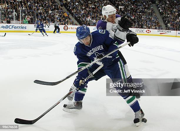 Steve Bernier of the Vancouver Canucks plays the puck as he is checked by Matt Greene of the Los Angeles Kings in Game Five of the Western Conference...