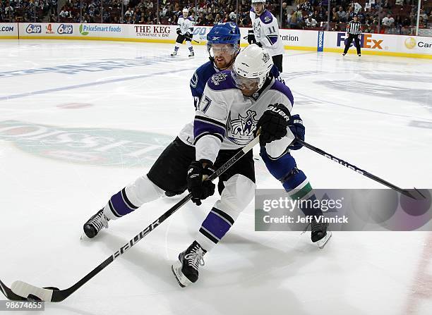 Wayne Simmonds of the Los Angeles Kings plays the puck as he is checked by Daniel Sedin of the Vancouver Canucks in Game Five of the Western...