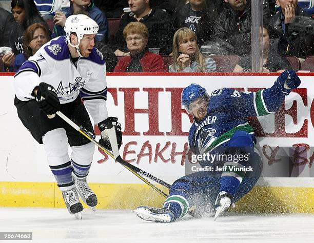 Daniel Sedin of the Vancouver Canucks is checked into the boards by Rob Scuderi of the Los Angeles Kings in Game Five of the Western Conference...