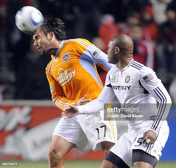 Mike Chabala of the Houston Dynamo heads the ball forward against John Collins of the Chicago Fire in an MLS match on April 24, 2010 at Toyota Park...