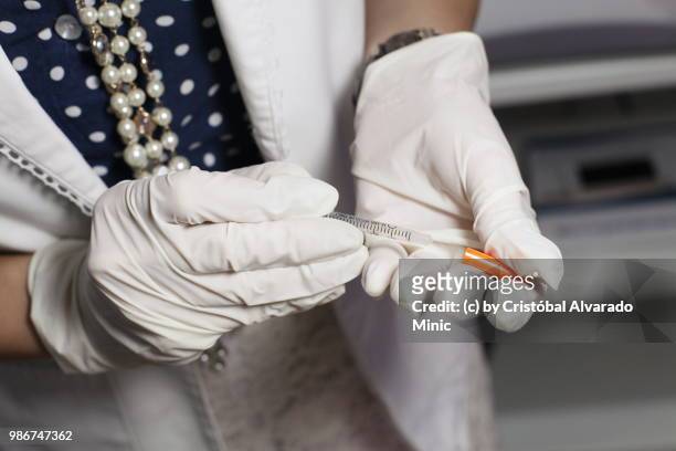 aesthetic doctor preparing syringe - carabobo stock-fotos und bilder
