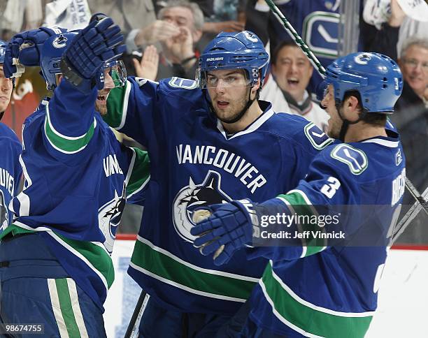 Pavol Demitra of the Vancouver Canucks is congratulated by teammates Steve Bernier and Kevin Bieksa after scoring in Game Five of the Western...