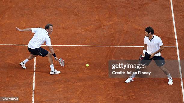 Roger Federer and Yves Allegro of Switzerland in action against Johan Brunstrom of Sweden and Jean-Julien Rojer of Netherlands Antilles during day...