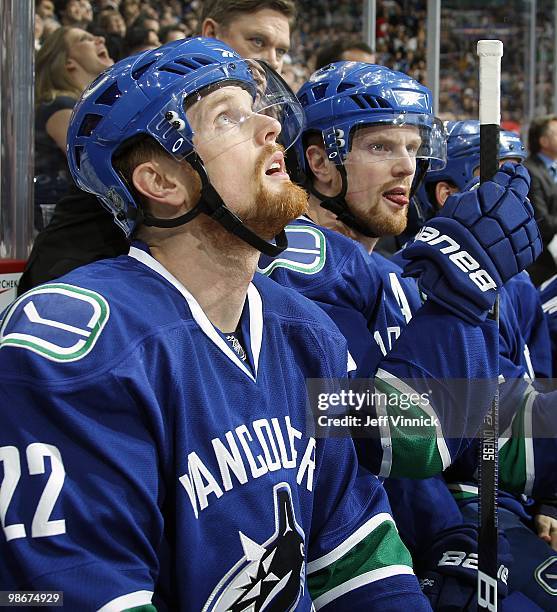 Daniel Sedin and Henrik Sedin of the Vancouver Canucks look on from the bench in Game Five of the Western Conference Quarterfinals in their game...