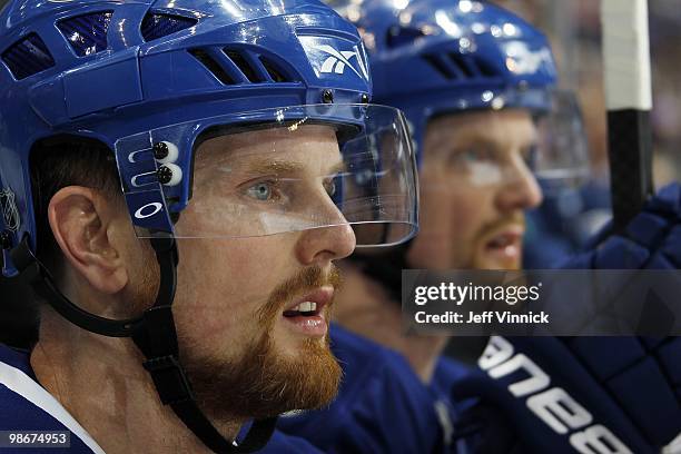 Daniel Sedin and Henrik Sedin of the Vancouver Canucks look on from the bench in Game Five of the Western Conference Quarterfinals in their game...