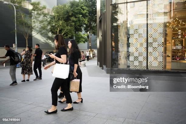 Pedestrians and shoppers walk past a Furla SpA store on Wangfujing Street in Beijing, China, on Wednesday, June 27, 2018. Consumer sentiment in China...