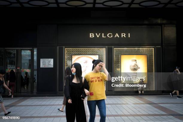 Pedestrians walk past a Bulgari SpA store on Wangfujing Street in Beijing, China, on Wednesday, June 27, 2018. Consumer sentiment in China remains...