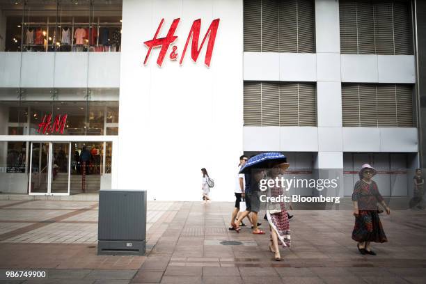Pedestrians walk past a Hennes & Mauritz AB store on Wangfujing Street in Beijing, China, on Wednesday, June 27, 2018. Consumer sentiment in China...