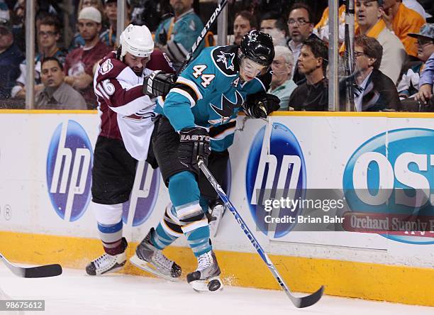 Marc-Edouard Vlasic of the San Jose Sharks kicks the puck away from Darcy Tucker of the Colorado Avalanche in Game Five of their Western Conference...