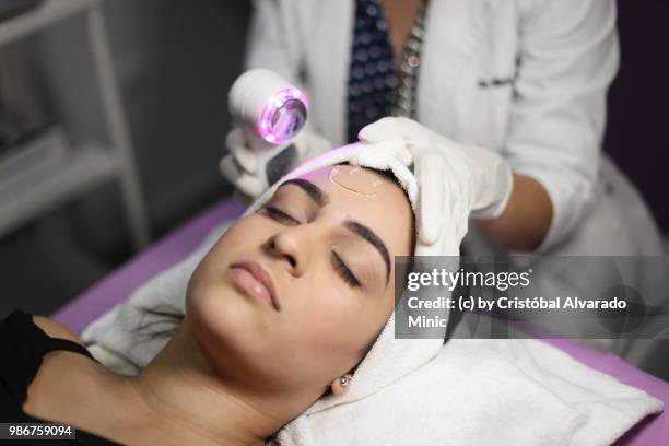 aesthetic doctor performs light-emitting diode session - carabobo stock-fotos und bilder