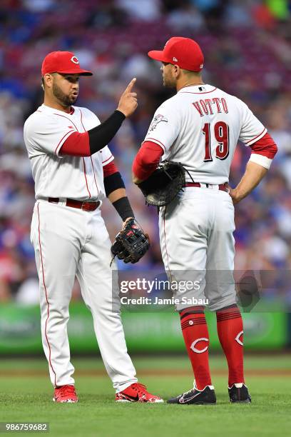 Eugenio Suarez of the Cincinnati Reds talks with Joey Votto of the Cincinnati Reds during a game against the Chicago Cubs at Great American Ball Park...