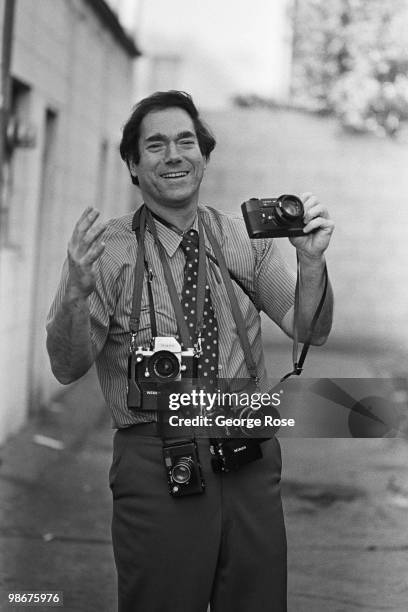 Claremont Courier owner and Publisher, Martin Weinberger, poses with his cameras during a 1975 Claremont, California, photo portrait in his offices.