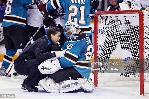 Trainer looks at goalie Evgeni Nabokov of the San Jose Sharks after physical play against the Colorado Avalanche in Game Five of their Western...