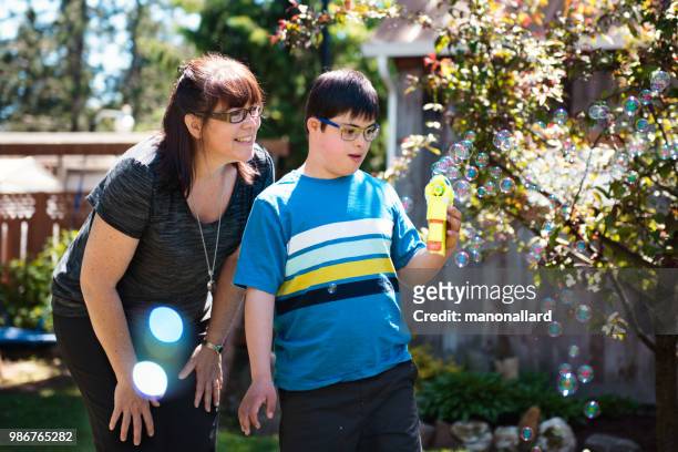 Mor och son med autism och Downs syndrom son i vardag