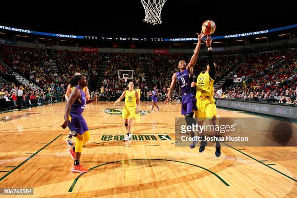 Alana Beard of the Los Angeles Sparks and Alysha Clark of the Seattle Storm reach for the ball on June 28, 2018 at Key Arena in Seattle, Washington....