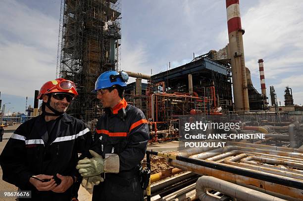 Workmen stand at the site of the mediterranean refinery of Lavera which belongs to British group Ineos, taken on April 26, 2010 in Martigues,...