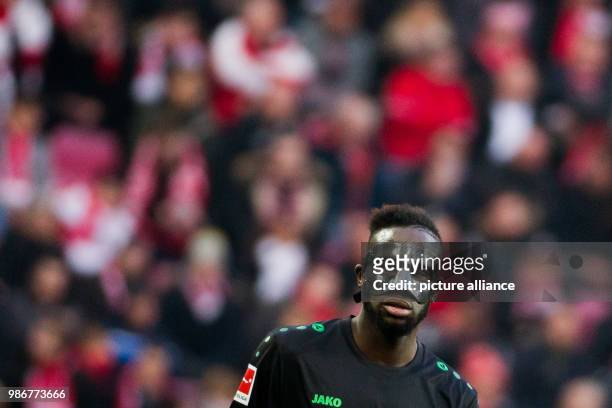 Hanover's Salif Sane plays with a mask during the German Bundesliga soccer match between 1. FC Cologne and Hanover 96 in the RheinEnergieStadion in...