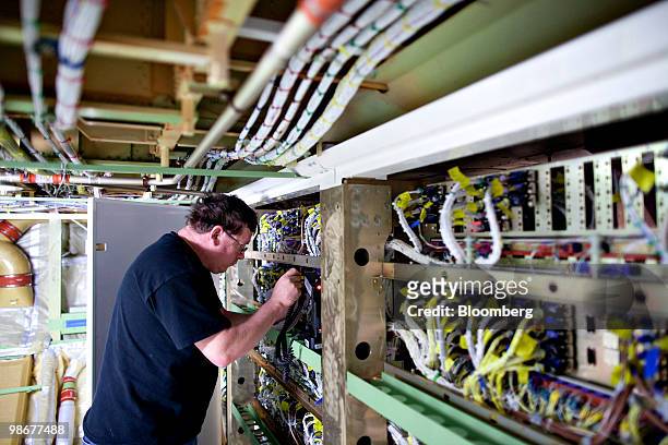 Andrew Adams inspects wiring inside a Boeing 747-8 cargo plane during final assembly in Everett, Washington, U.S., on Tuesday, March 16, 2010. The...