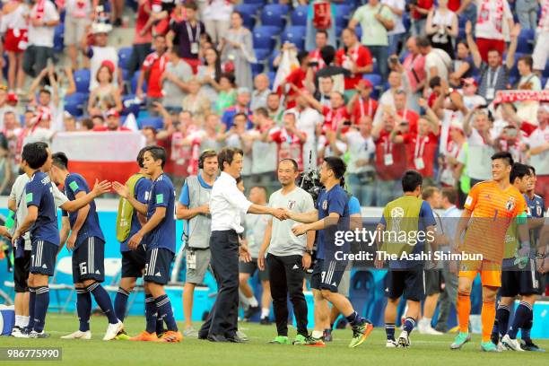 Head coach Akira Nishino of Japan shakes hands with Shinji Okazaki as they went through to the knockout stage despite the 0-1 defeat in the 2018 FIFA...