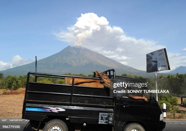 Car passes by as Mount Agung volcano erupts at the Kubu sub-district in Karangasem Regency on Indonesia's resort island of Bali on June 29, 2018. -...