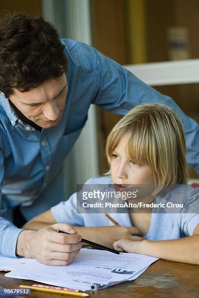 male junior high student listening as teacher explains difficult assignment - teacher bending over stock-fotos und bilder