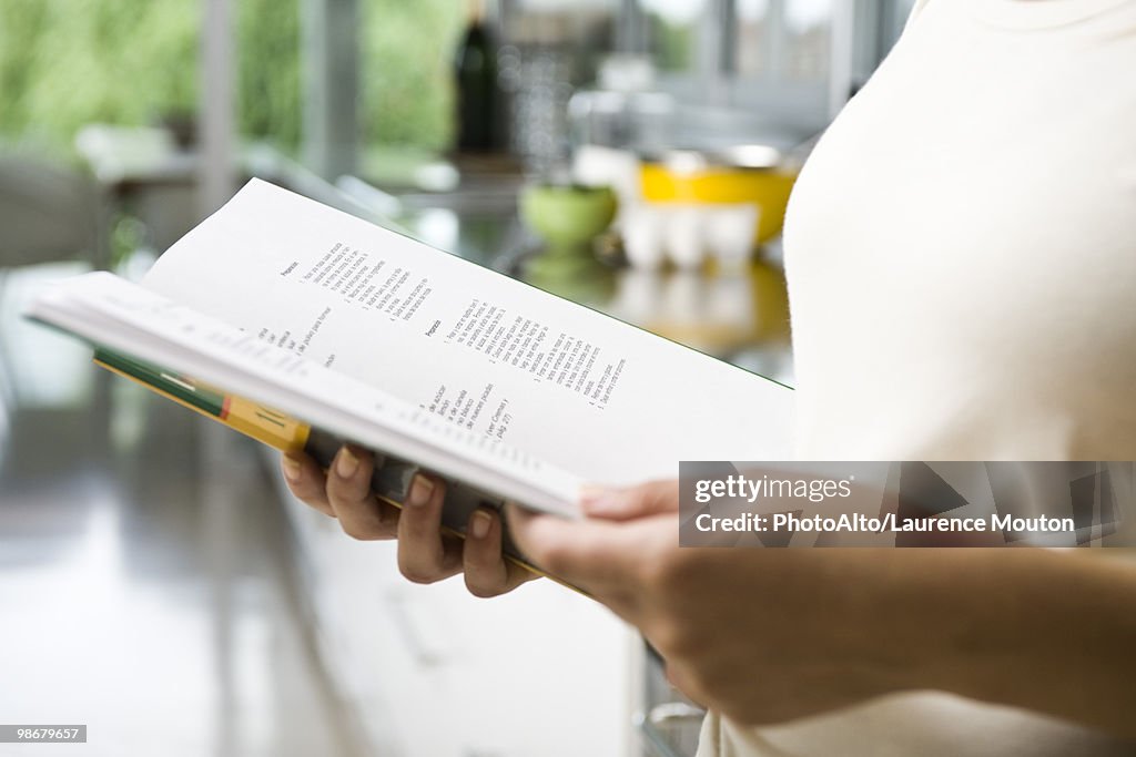 Reading recipe in cookbook