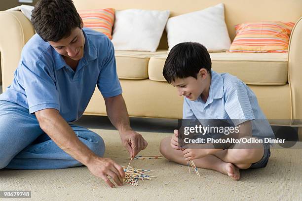 father and son playing pick up sticks - mikado stock pictures, royalty-free photos & images