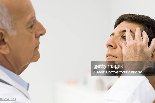 doctor checking patient's ocular health - ocular stock pictures, royalty-free photos & images