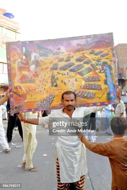 pakistani shia muslim carrying the holy map of the area where karbala war was fought between hazrat imam hussain and yazeed on his shoulders during a muharram procession - yazeed stock pictures, royalty-free photos & images