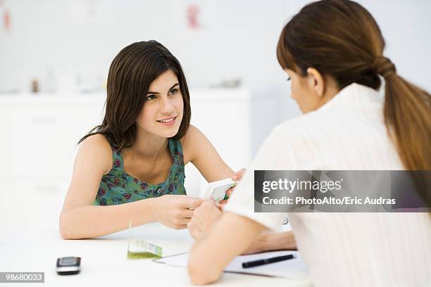 teenage girl discussing birth control pills with gynecologist - birth control stockfoto's en -beelden