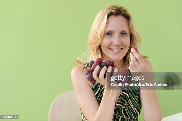 mature woman eating grapes - red grapes stock pictures, royalty-free photos & images