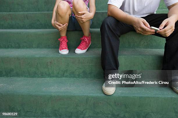 teenage couple sitting together on steps - shy teenager stock pictures, royalty-free photos & images